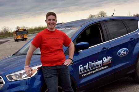 S4SD team advisor Dave Logel leans against blue Ford DSFL Mustang